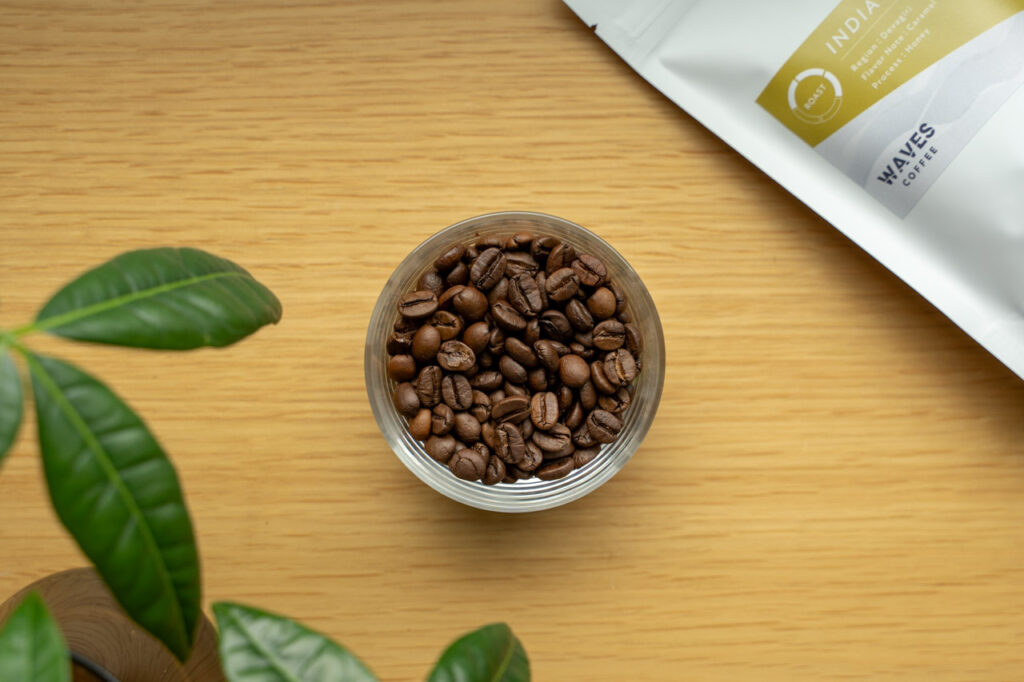 ガラスの器に入った焙煎したコーヒー豆とWAVES COFFEEの豆袋